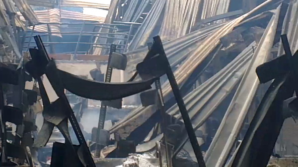 Now there is nothing left of the area except some twisted shelving and collapsed roofing material